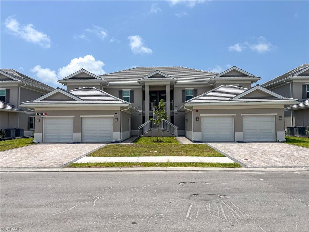 268 Indies Drive East, Unit 102 Naples, FL 34114 - Photo 37 of 48 a front view of a house with a yard and garage