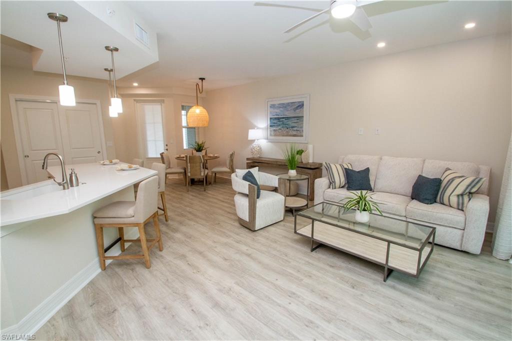 268 Indies Drive East, Unit 102 Naples, FL 34114 - Photo 8 of 48 a living room with furniture and a table