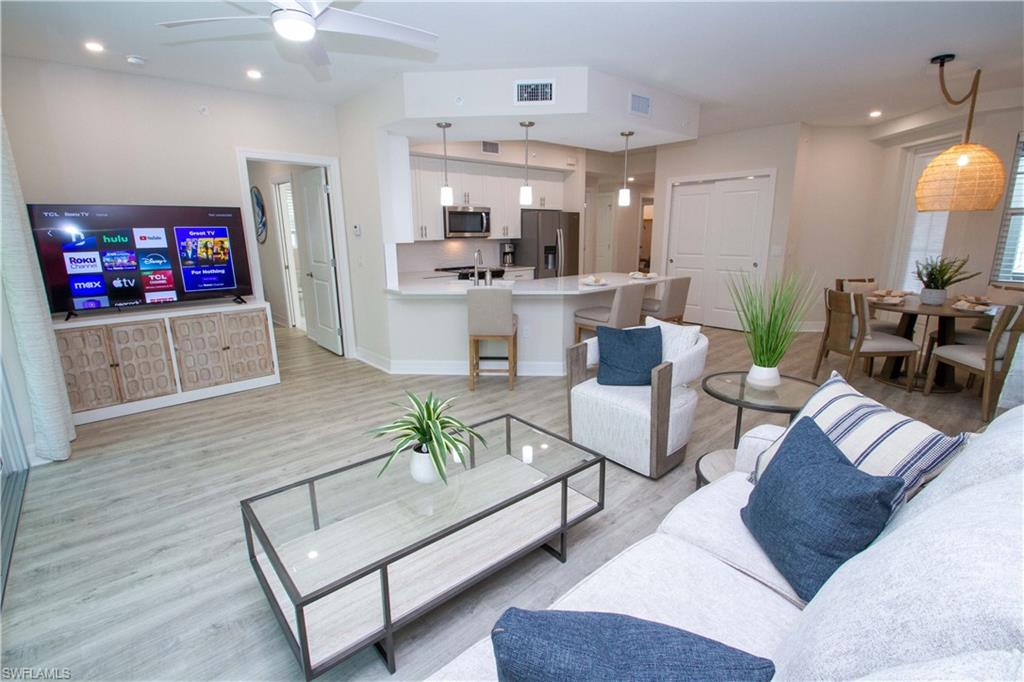 268 Indies Drive East, Unit 102 Naples, FL 34114 - Photo 9 of 48 a living room with furniture and a flat screen tv