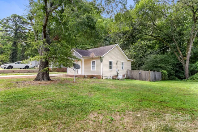 a view of a house with backyard and trees