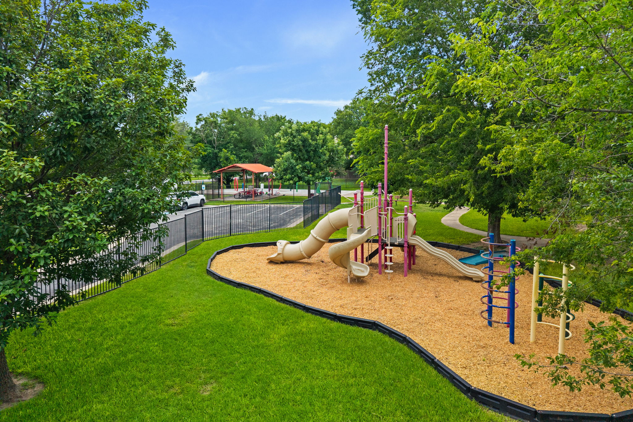 8902 Magna Carta Loop, Unit 122 Austin, TX 78754 - Photo 35 of 39 A vibrant playground set amidst verdant trees offers recreation and a picnic area nearby.