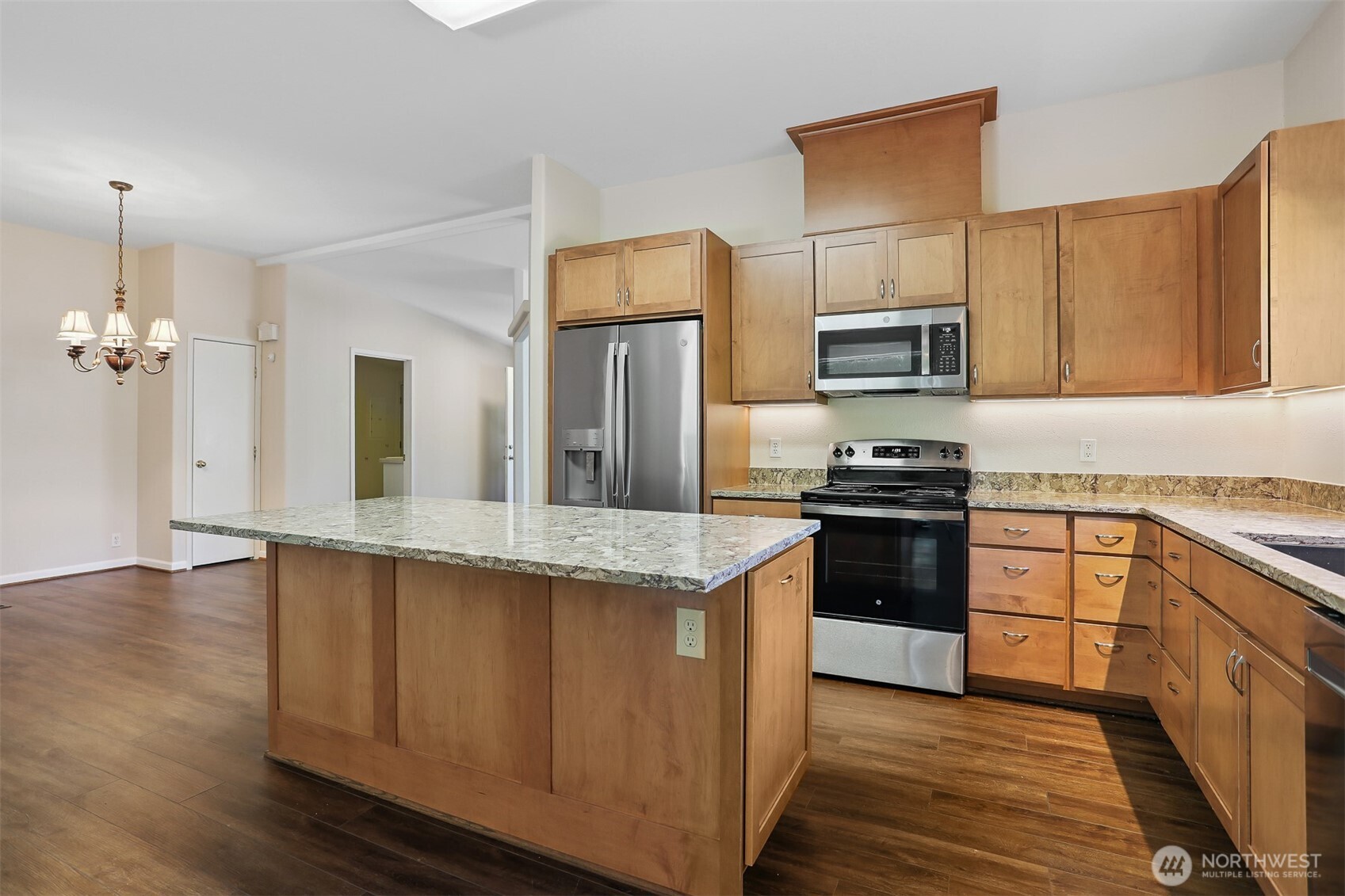 23701 9th Place West Bothell, WA 98021 - Photo 5 of 40 a kitchen with kitchen island granite countertop a stove top oven a sink dishwasher and a refrigerator with wooden floor