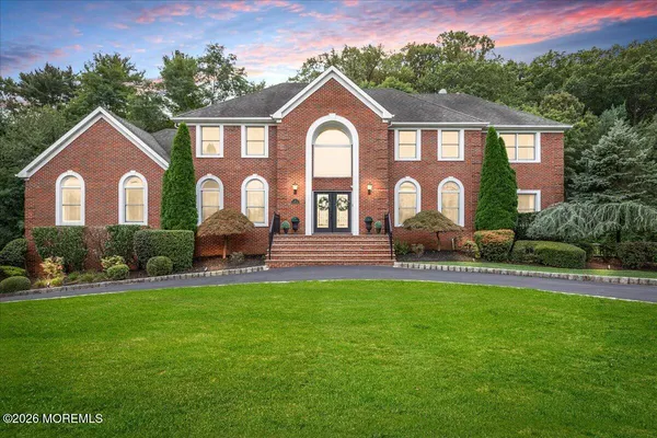 a view of a house with a big yard plants and large trees