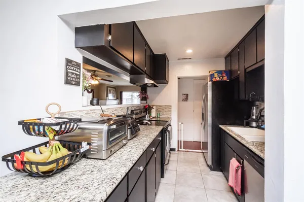a kitchen with kitchen island granite countertop a stove and a sink