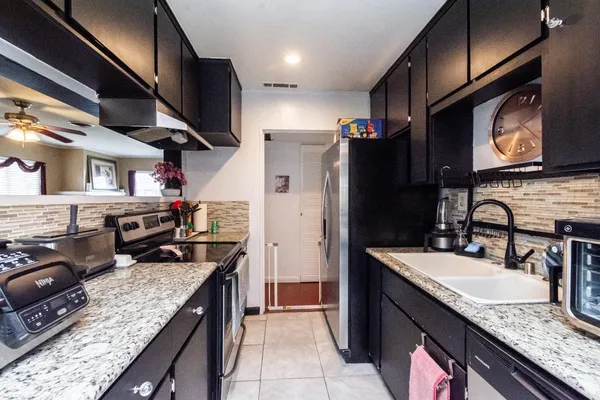 a kitchen with stainless steel appliances granite countertop a sink stove and refrigerator