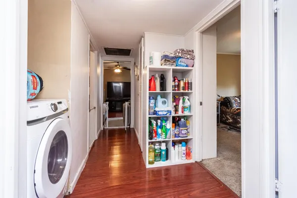 a view of a hallway with wooden floor and closet
