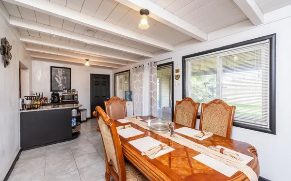 a dining room with furniture and a large window