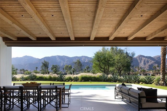 a view of outdoor sitting area with furniture and mountain view in back