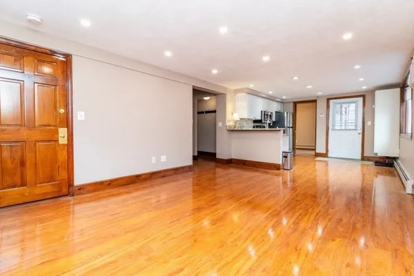 a kitchen with granite countertop a refrigerator stove top oven and cabinets with wooden floor