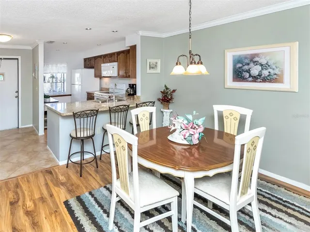 a dining room with furniture a chandelier and wooden floor
