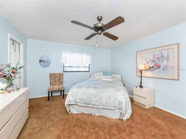 a spacious bedroom with a bed and a chandelier