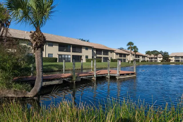 a view of a lake with a big yard and large trees