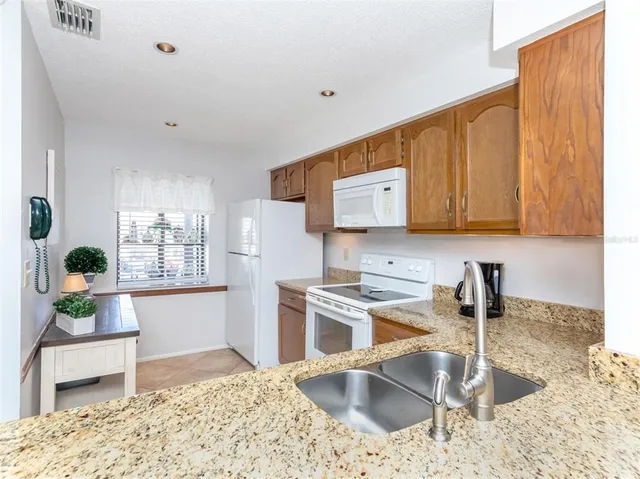 a kitchen with stainless steel appliances granite countertop a sink and a stove