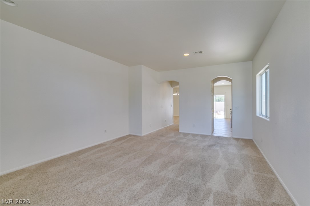 5150 Riverside Run Court North Las Vegas, NV 89081 - Photo 8 of 50 A spacious, naturally illuminated room featuring neutral carpeting and graceful arched doorways.