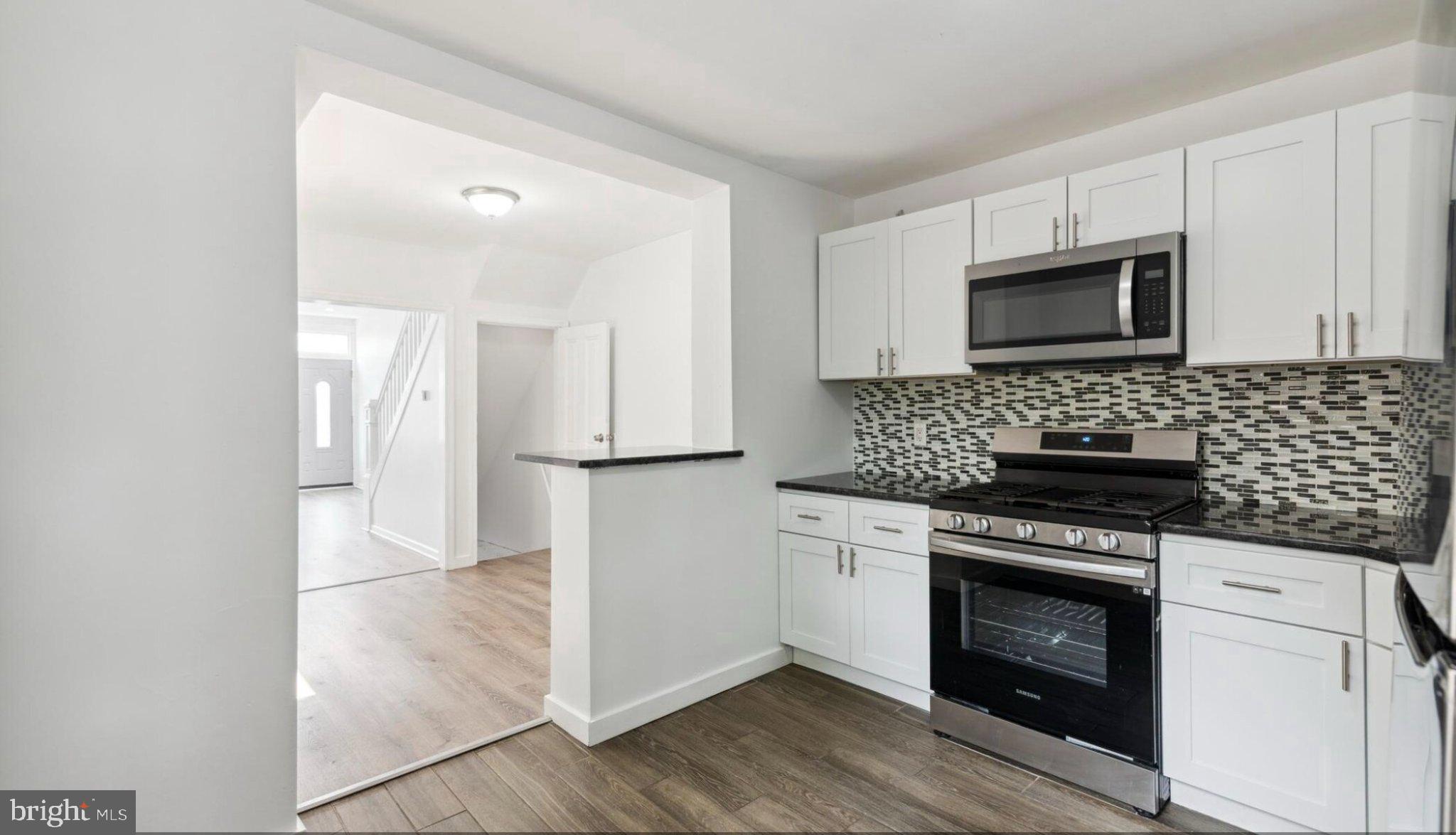 17 South 45th Street Philadelphia, PA 19104 - Photo 3 of 13 a kitchen with cabinets stainless steel appliances and wooden floor