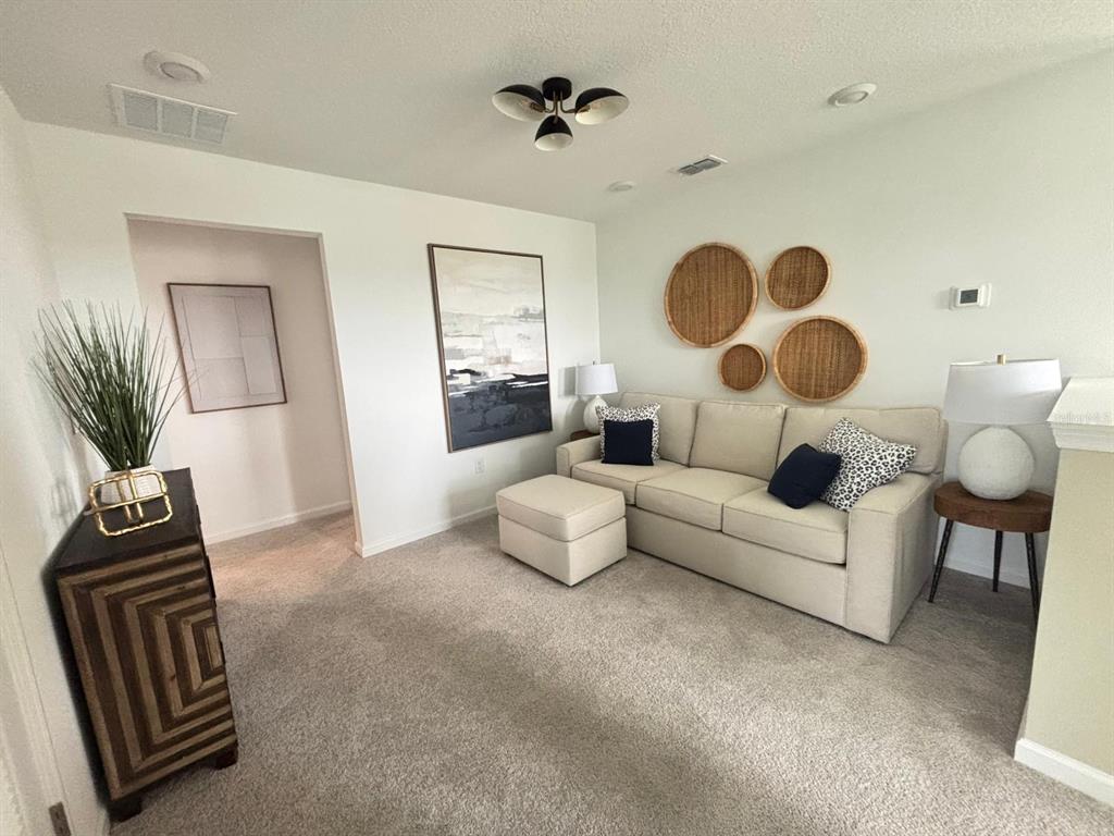 4738 Southwest 83rd Loop Ocala, FL 34476 - Photo 13 of 17 a living room with furniture and a chandelier