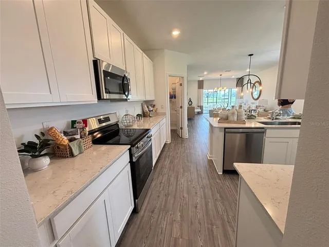 a kitchen with stove a sink and cabinets