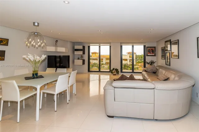 a living room with furniture a chandelier and a dining table