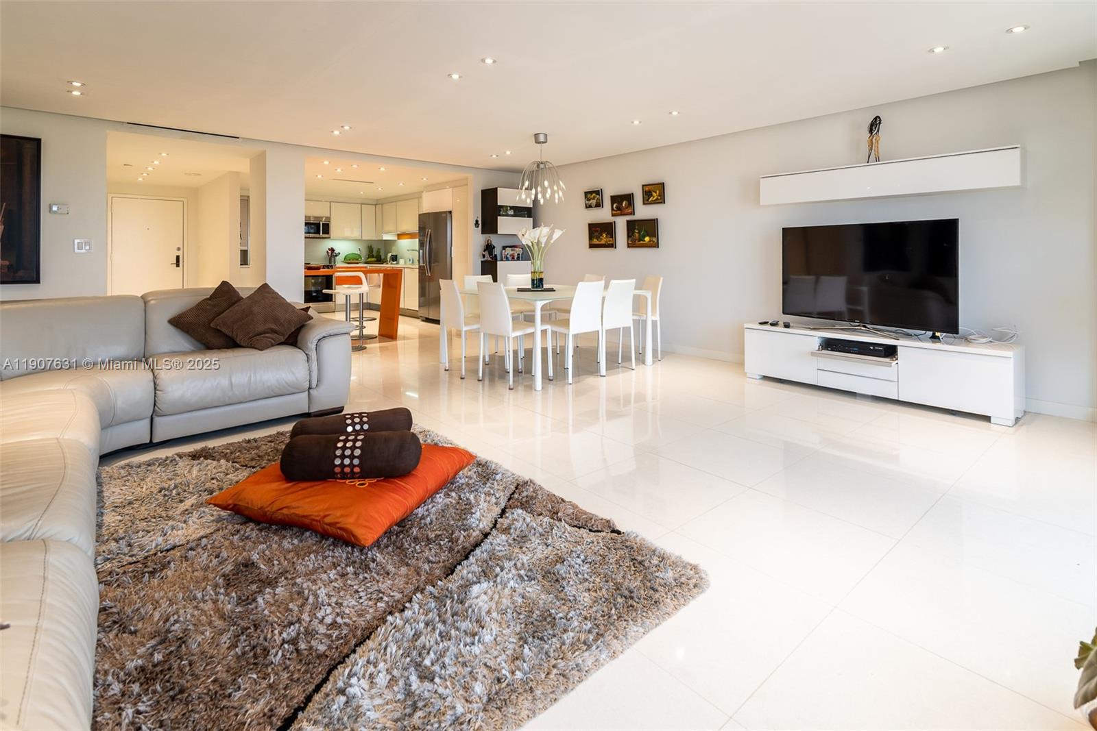 8877 Collins Avenue, Unit 604 Surfside, FL 33154 - Photo 6 of 25 a living room with furniture and a flat screen tv