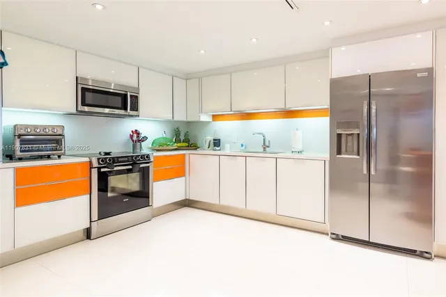 a kitchen with stainless steel appliances kitchen island granite countertop a refrigerator and a stove top oven