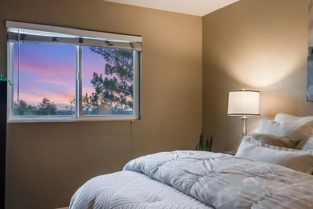 a bedroom with a bed and a painting on the wall