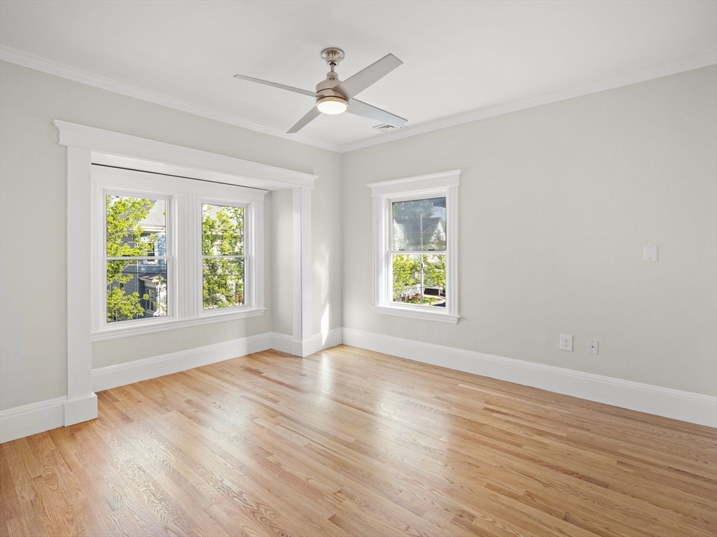 30 Baker Road Everett, MA 02149 - Photo 21 of 42 an empty room with wooden floor a ceiling fan and windows