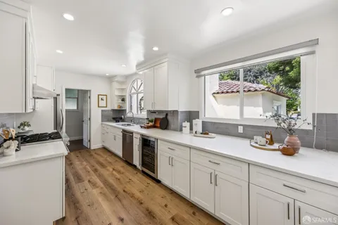 a kitchen with a sink and wooden floor