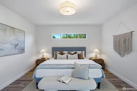 a bed room with a bed and painting on the wall