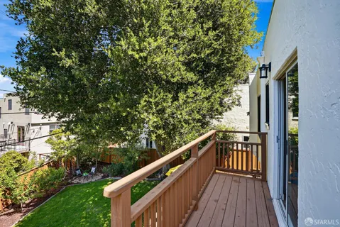 a view of a balcony with wooden floor and fence
