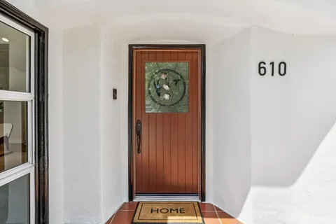 a view of a hallway to a livingroom with furniture wooden floor and window