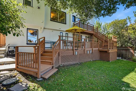 a view of a house with a yard and deck
