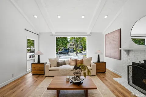a living room with furniture a large window and a fireplace