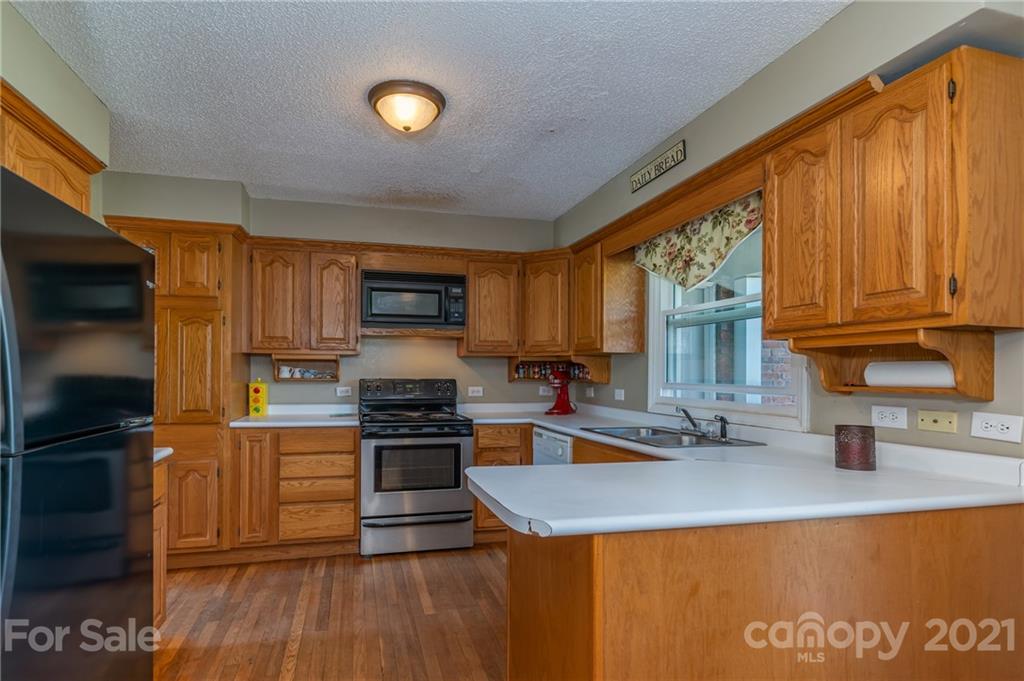 606 Old Stonecutter Road Rutherfordton, NC 28139 - Photo 16 of 48 a kitchen with stainless steel appliances granite countertop a stove a sink dishwasher a microwave oven and a refrigerator with wooden floor