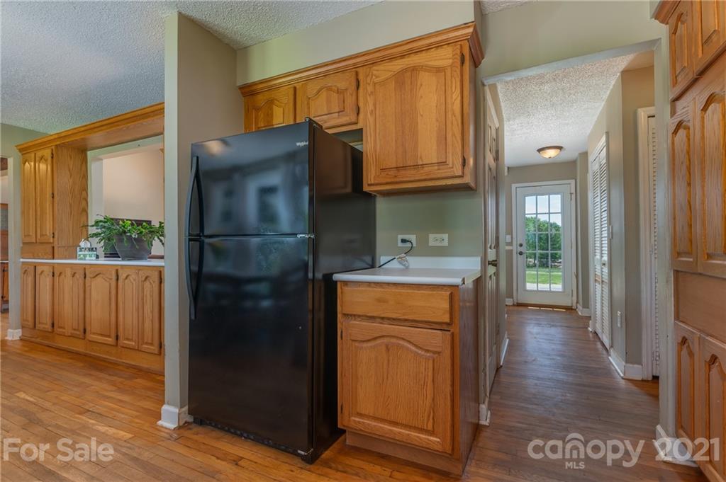 606 Old Stonecutter Road Rutherfordton, NC 28139 - Photo 18 of 48 a kitchen with stainless steel appliances granite countertop a refrigerator a sink and wooden cabinets with wooden floor