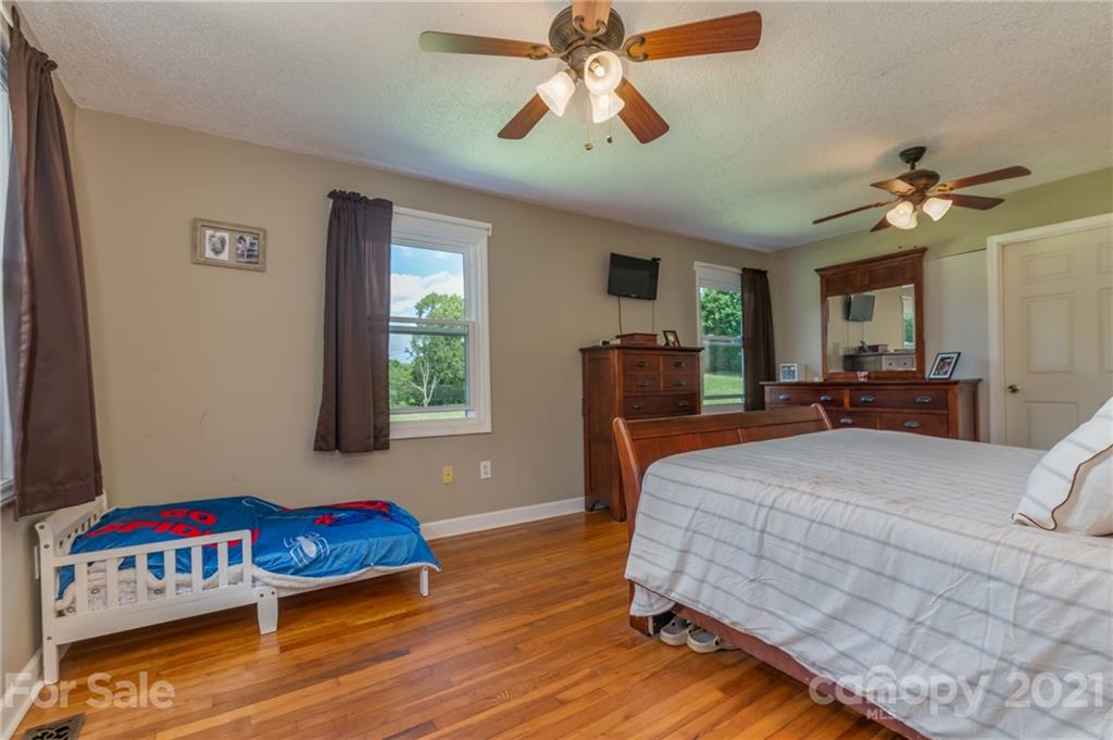 606 Old Stonecutter Road Rutherfordton, NC 28139 - Photo 20 of 48 a bedroom with a bed and a chandelier