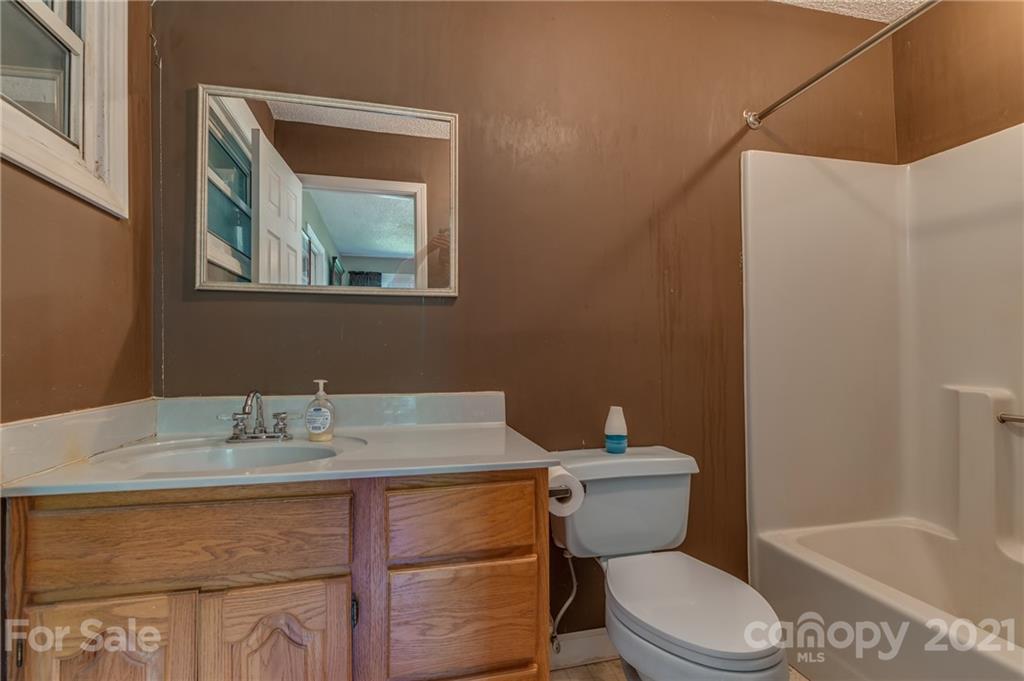 606 Old Stonecutter Road Rutherfordton, NC 28139 - Photo 21 of 48 a bathroom with a granite countertop toilet sink and mirror