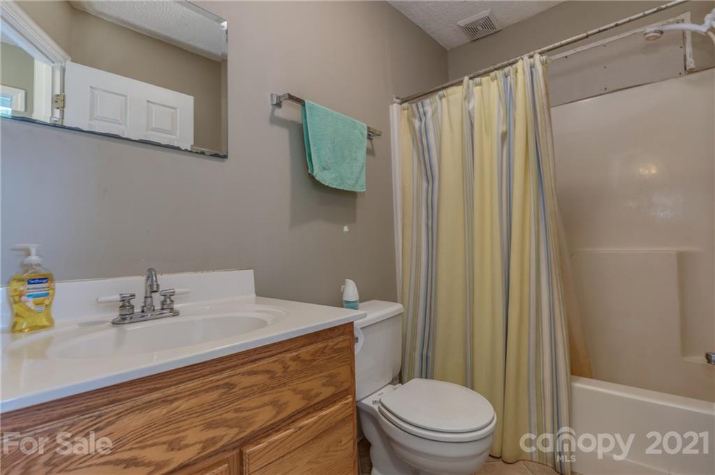 606 Old Stonecutter Road Rutherfordton, NC 28139 - Photo 25 of 48 a bathroom with a sink a toilet and shower curtain