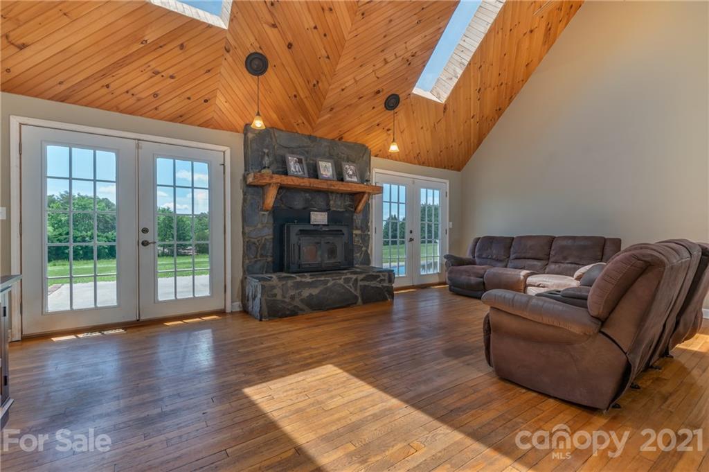 606 Old Stonecutter Road Rutherfordton, NC 28139 - Photo 6 of 48 a living room with furniture a fireplace and a floor to ceiling window