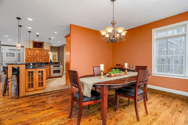 a dining room filled chandelier and wooden floor