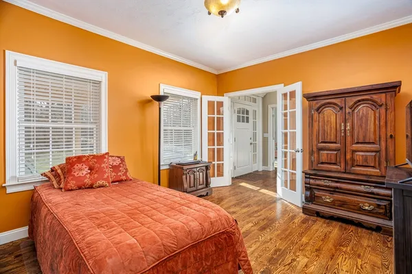 a bedroom with bed and wooden floor