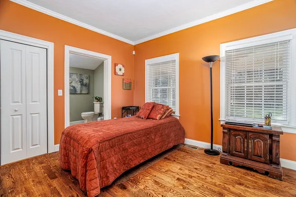 a bedroom with a bed and wooden floor