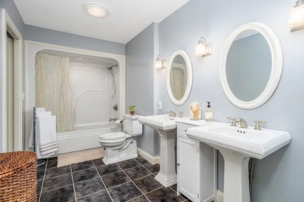 a bathroom with a double vanity sink mirror and toilet