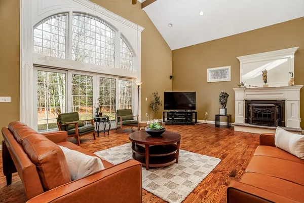 a living room with furniture a flat screen tv and a large window