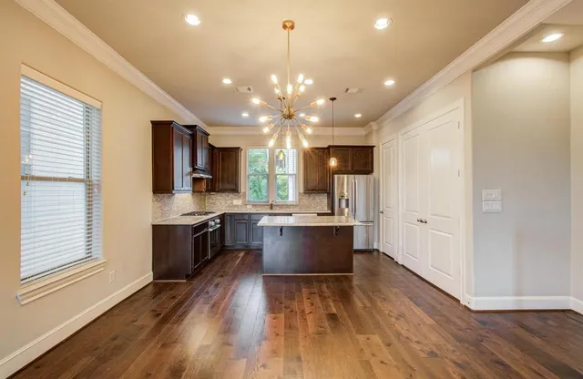 a large kitchen with granite countertop a large counter top space a sink stainless steel appliances and cabinets