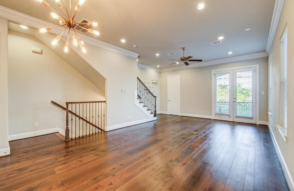 610 Delano Street Houston, TX 77003 - Photo 15 of 36 a view of a livingroom with wooden floor a ceiling fan and windows