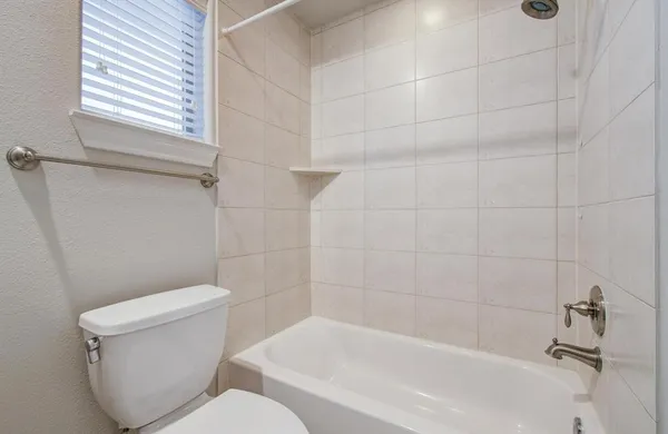 a white toilet sitting next to a bath tub and a shower