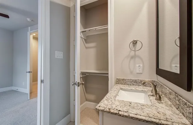 a bathroom with a granite countertop sink and a mirror