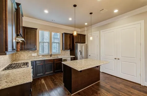 a kitchen with kitchen island granite countertop a stove and a sink