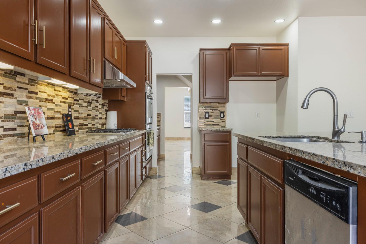 3105 Ripple Court Modesto, CA 95355 - Photo 15 of 46 a kitchen with stainless steel appliances granite countertop a sink a stove and a refrigerator