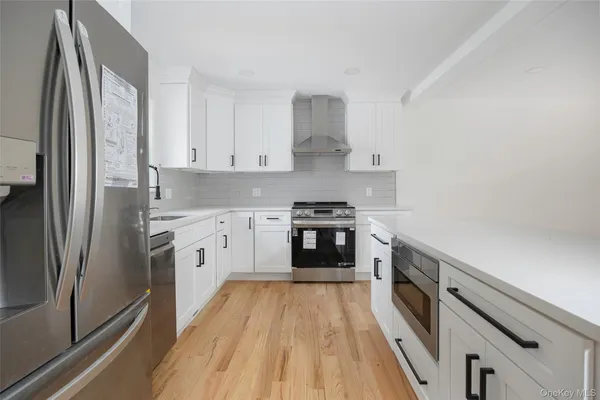 a kitchen with stainless steel appliances a white stove top oven and a wooden floors